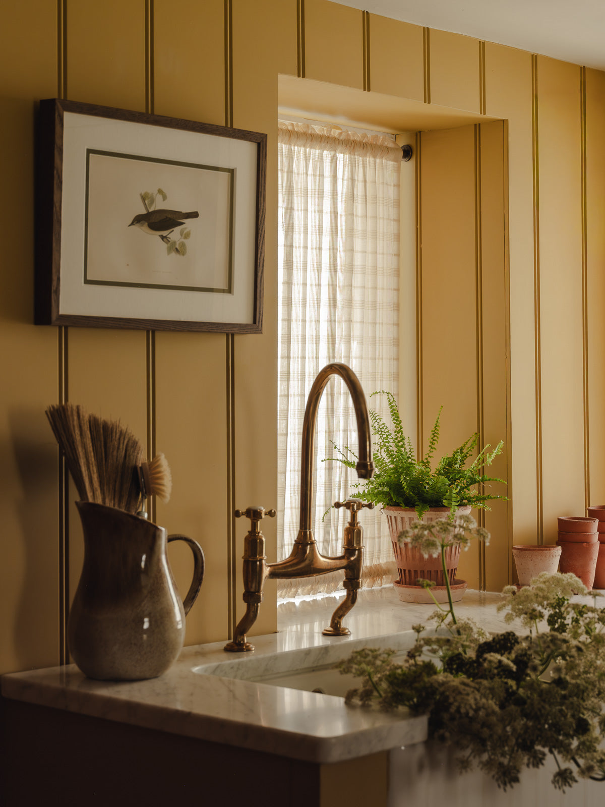 Double rod pocket café curtain in Elva cotton check, on brass poles top and bottom in a utility room at Baywell Studio