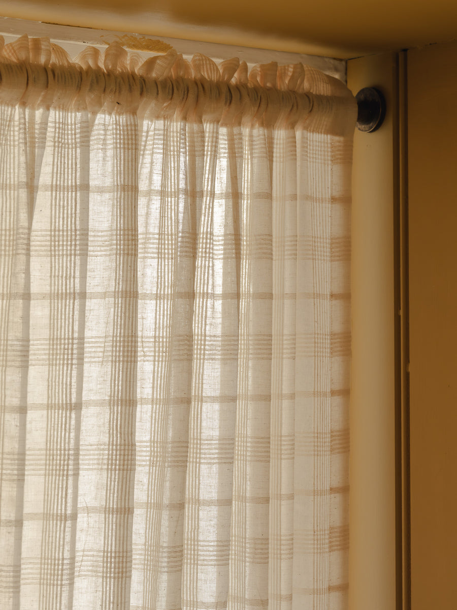 Double rod pocket café curtain in Elva cotton check, on brass poles top and bottom in a utility room at Baywell Studio
