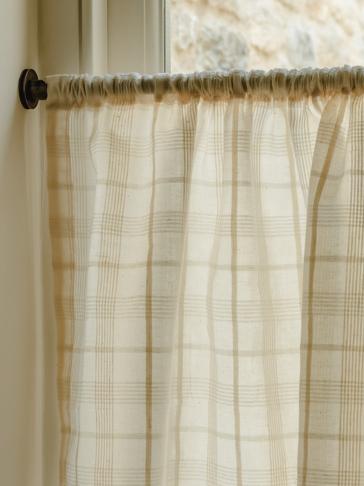 Rod pocket café curtain in Elva, an Indian cotton fine check weave, gathered on a slim brass pole at Baywell Studio