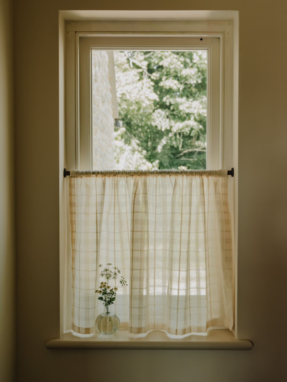 Wide shot  rod pocket café curtain in Elva, an Indian cotton fine check weave, gathered on a slim brass pole at Baywell Studio